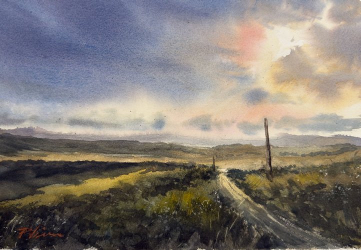 Scenic landscape with a path leading towards a rainbow in the sky