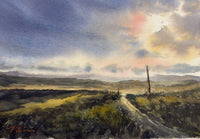 Scenic landscape with a path leading towards a rainbow in the sky